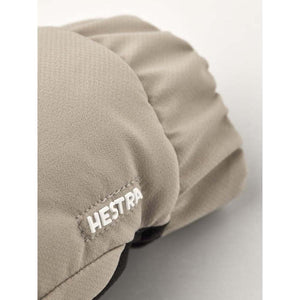 Beige warming glove by Hestra, featuring a subtle textured fabric and embroidered logo on the side.