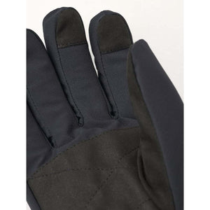 Black gloves by Hestra with touchscreen fingertips and a quilted palm, angled close-up.