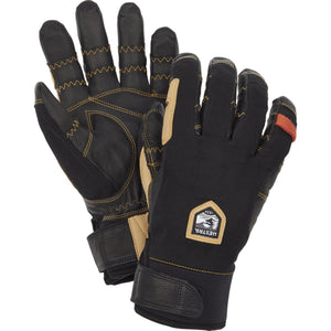 Black and tan short gloves by Hestra, with yellow stitching, a logo patch, and adjustable wrist straps.