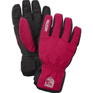 A pair of red and black winter gloves by Hestra, featuring the brand name on the back and a logo on the wrist cuff.