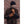 Brown nubuck leather gloves by Hestra with visible stitching, worn by a man in a brown fleece jacket.