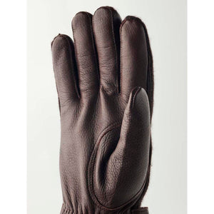 Dark brown leather gloves by Hestra with a visible plush lining and textured finish.