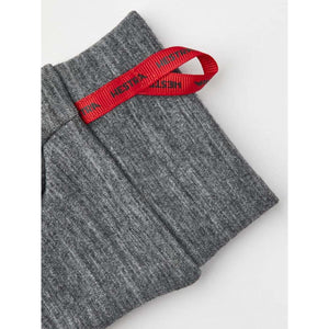 Heather grey 5-finger thin inner gloves by Hestra, made of knit fabric with a red ribbon loop featuring the brand name.
