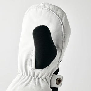 Close-up of a white leather junior mitten by Hestra with black detail, elastic wrist, and snap button closure.