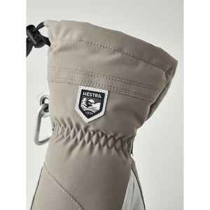Gray women's mitt by Hestra with a logo patch, cinched wrist, and attached carabiner clip.