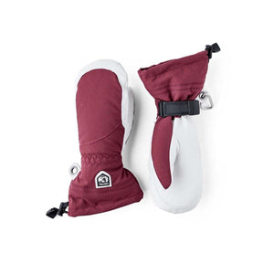A pair of women's maroon and white Heli Mitts by Hestra, featuring adjustable wrist straps, drawstring cuffs, and a logo patch.