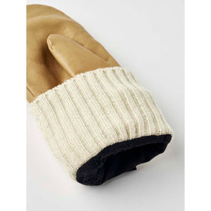 Tan leather mittens by Hestra with an off-white ribbed knit cuff and black lining visible.