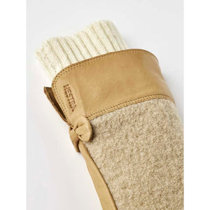 Tan leather and beige wool-blend mitten by Hestra, with an off-white ribbed knit cuff and a leather knot accent.