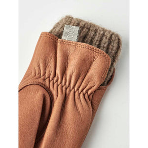 Women's tan deerskin glove by Hestra with gathered wrist detailing, a ribbed knitted cuff, and a patterned loop.
