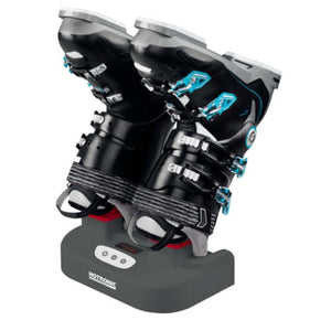 Dark gray boot dryer by Hotronic holding two black ski boots with blue buckles.