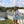 Mint green and white backpack cooler by Kanga Coolers, worn by a smiling woman in a white jacket on a rooftop.
