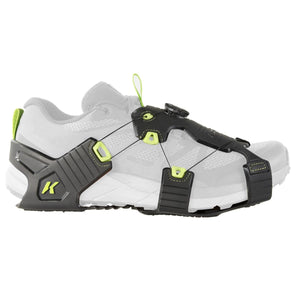 Black and grey Winter Ice Runner by Korkers with neon green accents, dial lacing system, and K logo, attached to a white sneaker, side view.