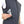 Dark gray men's heat vest by Lenz, sleeveless, with a hand putting a silver smartphone into a zippered side pocket.