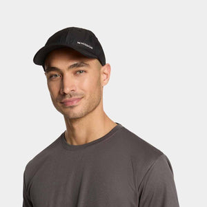 Black Cooling Performance Hat by Mission with white logo, worn by a man in a gray shirt.