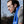 Blue cooling towel by Mission with a visible M logo, draped around a man wearing a grey t-shirt and eye black.