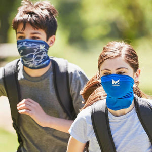 Grey camo youth cooling neck gaiter by Mission on a boy running with a girl in a blue gaiter.
