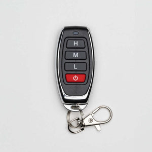 Black and silver remote control by Mobile Warming, with '0', 'H', 'M', 'L', and power buttons, and an attached keychain with carabiner.