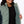 Women's Aria Hybrid Heated Jacket by Mobile Warming with a sage green quilted front, dark teal sleeves, and topographic map lining, worn partially unzipped.