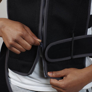 Black mesh Cooling Vest with grey trim by Oro Sports, being zipped up by hands over a white t-shirt.