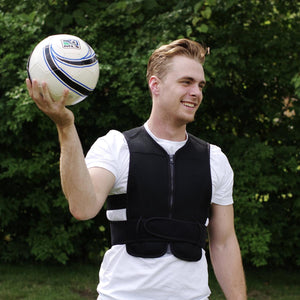 Black cooling vest by Oro Sports, worn by a smiling man in a white t-shirt holding a soccer ball outdoors.