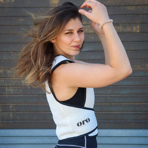White mesh cooling vest by Oro Sports with black trim and logo, worn by a woman, side view.