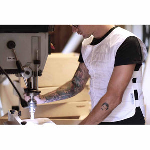 White quilted cooling vest by Peke Safety worn by a man operating a drill press.