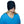 Black cold therapy extended head cap by Polar Products, covering the eyes of a smiling person wearing a blue shirt.