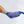 Universal U-shaped therapy pad in blue with a purple striped elastic wrap by Polar Products on a person's foot wearing a grey sock.