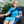 Dark blue Universal U-Shaped Therapy Pad by Polar Products with an elastic belt and attached blue hose on a woman's shoulder.