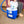 Blue and white 16-quart cooling reservoir by Polar Products with a blue hose, a person places a frozen bottle inside.