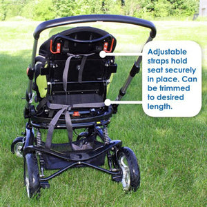 Back view of a black toddler stroller seat by Polar Products featuring grey adjustable straps in a stroller frame on green grass.