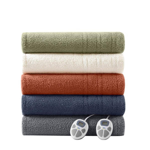 Stack of five soft heated blankets by Serta in various colors with two controllers visible.