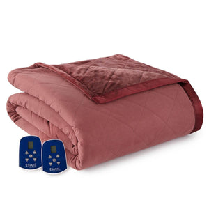 Dusty rose full-size electric heated blanket by Shavel with a quilted pattern, plush trim, and two blue remote controls.
