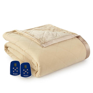 Beige quilted electric heated blanket by Shavel, folded showing a soft texture, satin trim, and two blue controllers.