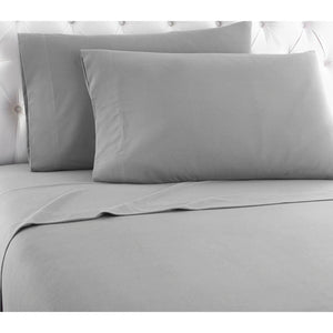 Grey Cal King solid color micro flannel sheet set by Shavel, on a bed with two pillows and a white tufted headboard.