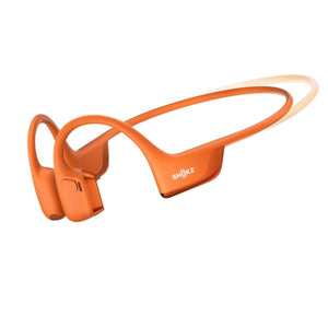 Orange bone conduction mini headphone by Shokz, angled with a flexible band indicated by a dotted line.