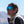 Matte black sunglasses with blue mirror lenses by Smith Optics, featuring a logo on the temple, worn by a man in a sherpa vest.
