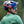 Sunglasses with blue mirrored lenses and a matte black frame by Smith Optics, worn by a man with a mustache, helmet, and green jersey, side view.