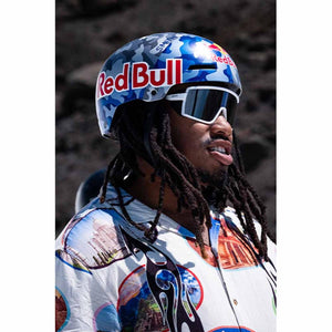 Blue camouflage helmet by Smith Optics, worn by a person with dreadlocks and white goggles, featuring a Red Bull logo.