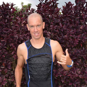 Black evaporative cooling tank top by HyperKewl with quilted front panel and blue trim, worn by a smiling man.
