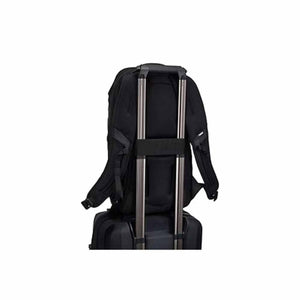 Black Laptop Backpack by Thule, back view, attached to a rolling suitcase handle via a pass-through strap.