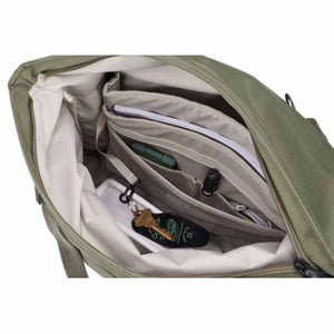Green 22L tote bag by Thule with an open top revealing organized interior pockets holding a notepad, pen, flashlight, phone, and keys.