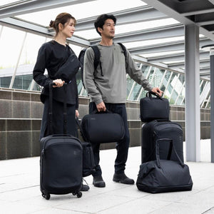 Black 16 Inch laptop and Tablet Attache by Thule held by a man in an outdoor setting with matching black luggage.