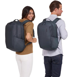 Dark grey backpack by Thule worn by a man and woman from the back, highlighting its sleek design.