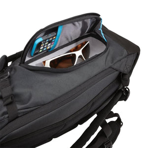 Dark Shadow Gray 25L backpack by Thule with an open top compartment showing a phone and sunglasses.