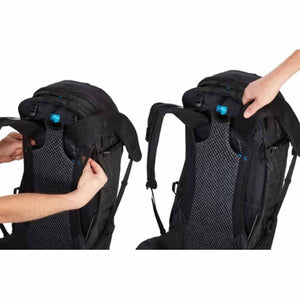 Black 30L backpack by Thule with mesh back panel, shown with hands adjusting the shoulder straps.