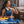 White and gold bladeless neck air conditioner by Torras, worn by a woman in athletic wear, drinking water.