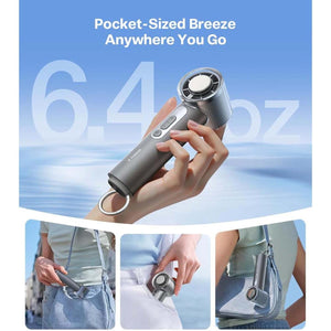 Compact charcoal handheld fan with ice cooler by Torras, held in a hand and demonstrated for portability in a bag and pocket.