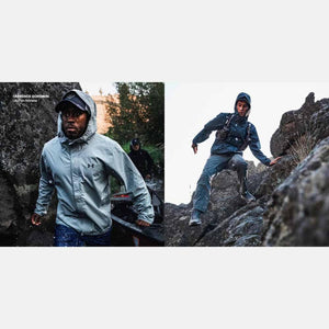 Light grey men's hooded full-zip jacket by Under Armour, with UA logo, worn by an athlete wading through a rocky stream.