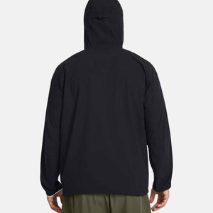 Black hooded men's jacket by Under Armour, shown from the back, with green pants.
